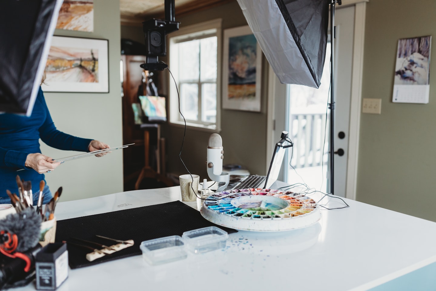 Creative professional organizing art supplies at a home studio desk.